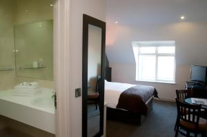 卡洛丁恩瑞酒店的浴室设有床、水槽和镜子