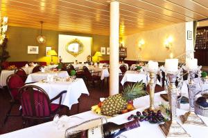 巴特维尔德巴德魏因加特纳酒店的用餐室配有带白色桌布的桌子