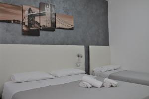 托雷拉皮罗B&B Il Molo的一间卧室设有两张床和一座桥梁