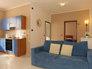 贝拉吉奥粉红之家公寓酒店的一间带蓝色沙发的客厅和一间厨房