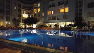 阳光海滩Niko Apartments的一座游泳池,在晚上在建筑物前