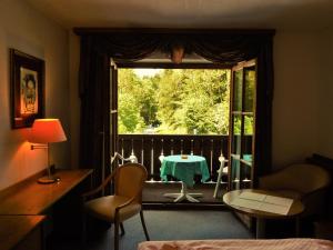 柯尼希斯湖畔舍瑙库尼格斯酒店的客房设有带窗户和桌子的卧室