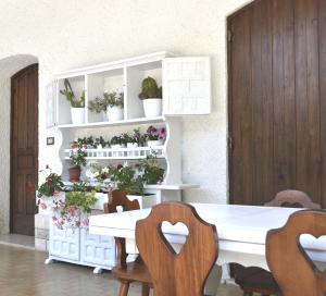 梅林La Frantoiana的一间设有白色桌子和一些植物的用餐室