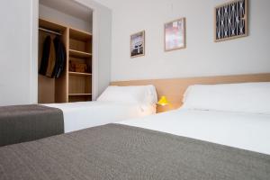 瓦伦西亚法兰西亚夫拉特斯达德拉斯森西亚酒店的配有白色床单的酒店客房内的两张床