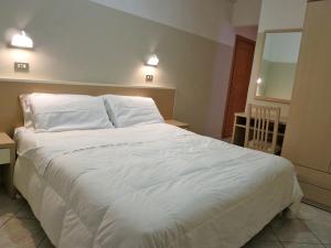 里米尼罗米纳酒店的卧室里一张大白色的床,有两盏灯