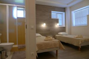 Vääna费耶纳旅馆的浴室设有两张床、卫生间和镜子