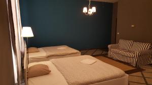 布达佩斯普瑞梅尔公寓旅馆的客房设有两张床、一把椅子和吊灯。