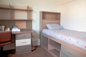 坎特伯雷Keynes College的一间小卧室,配有双层床和书桌