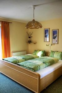 维尔芬翁Haus Silvia的一间卧室配有一张带绿色床单的大床