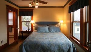 FleischmannsBreezy Hill Inn的一间卧室设有一张大床和两个窗户