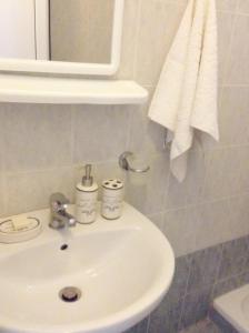 帕拉西亚斯Akrogiali Apartments的浴室设有白色水槽和镜子