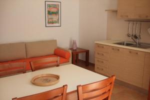 切萨雷奥港Residence La Corte的厨房以及带桌子和沙发的客厅。