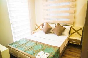 安塔利亚阿莱公寓的卧室配有带枕头的床铺和窗户。