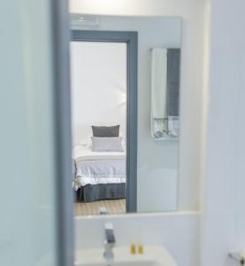 卡塞雷斯Casa Rural Castillo de Cáceres的浴室镜子,卧室内有一张床