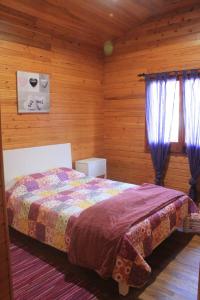 富尔纳斯Casa dos Manos的木制客房内的一间卧室,配有一张床