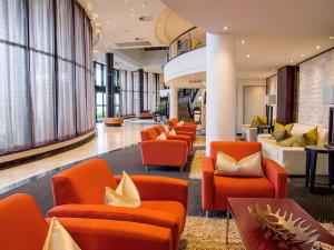 东伦敦东伦敦ICC普瑞米尔酒店的大堂设有橙色椅子和沙发。