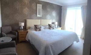 锡豪西斯斯普林伍德酒店的卧室配有白色床、椅子和窗户