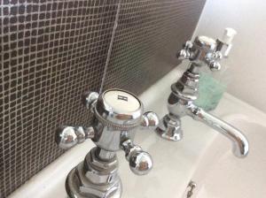 锡豪西斯斯普林伍德酒店的铬浴室盥洗盆,配有镜子和浴缸