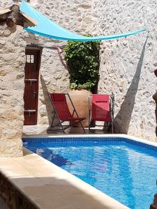 Patró卡萨萨斯特塞吉酒店的一个带两把椅子的庭院和一个游泳池
