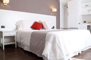 埃斯特角城米兰酒店的卧室配有白色的床和红色枕头