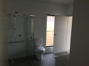 金斯科特金斯科特湾公寓式酒店的一间带卫生间和玻璃淋浴间的浴室