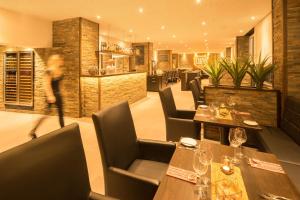 杜塞尔多夫空中瓦尔特堡酒店的一间带木桌椅的餐厅和一间酒吧