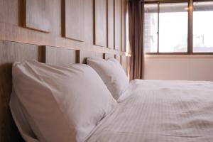 台中市奇异果-站前一馆的一张带白色床单和枕头的床,靠窗