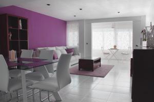 瓦伦西亚甜美卡罗琳公寓的一间拥有紫色墙壁和桌椅的用餐室