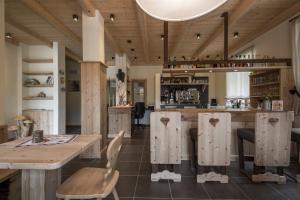 卡斯泰洛泰西诺Albergo Chalet Abete Rosso的一个带木桌和椅子的大厨房