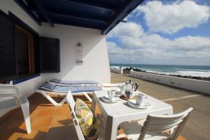蓬塔穆赫雷斯Casita Lanzaocean view的阳台上配有白色的桌椅,享有海景