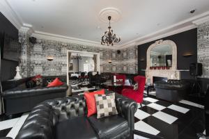 伦敦伦敦Park International酒店的客厅配有黑色皮革家具和壁炉