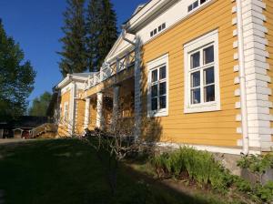 SulkavaTiittalan Kartano的黄色的房子,有白色的窗户和院子