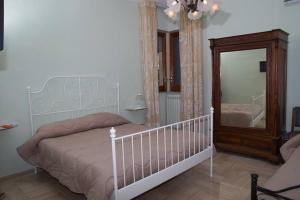安德里亚B&B La Bougainvillea的卧室配有白色的床和镜子