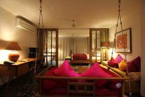 拉杰果德The Sky Imperial Aarivaa Luxury HomeStay的客厅配有粉红色枕头的沙发