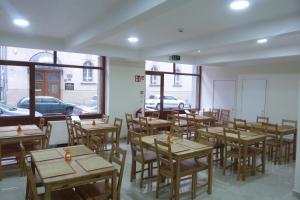 布达佩斯中心旅馆的餐厅设有木桌、椅子和窗户。