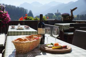 圣维吉利奥Gasthof La Pli Apartments的一张桌子,上面放着一篮面包和一瓶葡萄酒