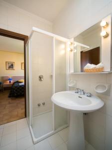 圣奇诺·迪·蒙塔尼亚中央酒店的白色的浴室设有水槽和淋浴。