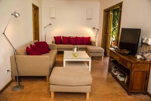 拉斯加勒拉斯Villa Ixora - Ocean Front的带沙发和红色枕头的客厅