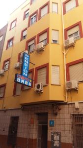 穆尔西亚坎波伊膳食公寓酒店的黄色的建筑,前面有标志