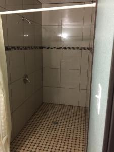 洛杉矶帕克汽车旅馆的配有玻璃门的淋浴,铺有瓷砖地板