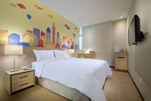 永和晶赞都会旅店-永和的卧室配有一张白色大床和电视。