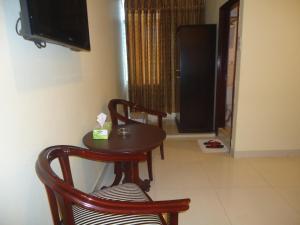 吉大港行政旅馆的一张桌子和两把椅子,以及客房内的一台电视机