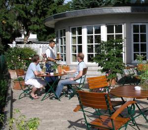 明登精美酒店的一群坐在花园里桌子上的人