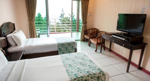 昆达桑京那巴鲁西岭度假酒店的酒店客房设有两张床和一台平面电视。