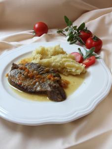 Grahovo图里斯提纳麦提亚卢格尔旅馆的一块食物,有肉,土豆泥和西红柿