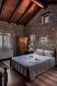 ThimiáVilla Fabrica的卧室配有一张石墙内的大床