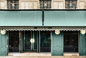 巴黎Handsome Hotel的绿色入口,带绿色遮阳篷的建筑
