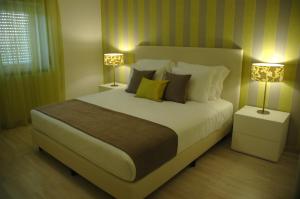阿雷亚布兰卡Hotel Dom Lourenco的一间卧室配有一张大床和两盏灯