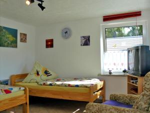 ParowBungalow Stralsund的一间卧室设有两张床、一台电视和一扇窗户。