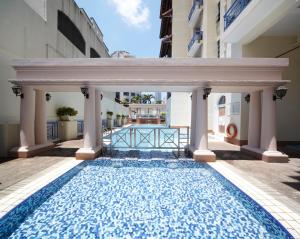 新加坡远东集团悦乐罗伯森码头公寓的一座带柱子的建筑中的游泳池,一座游泳池